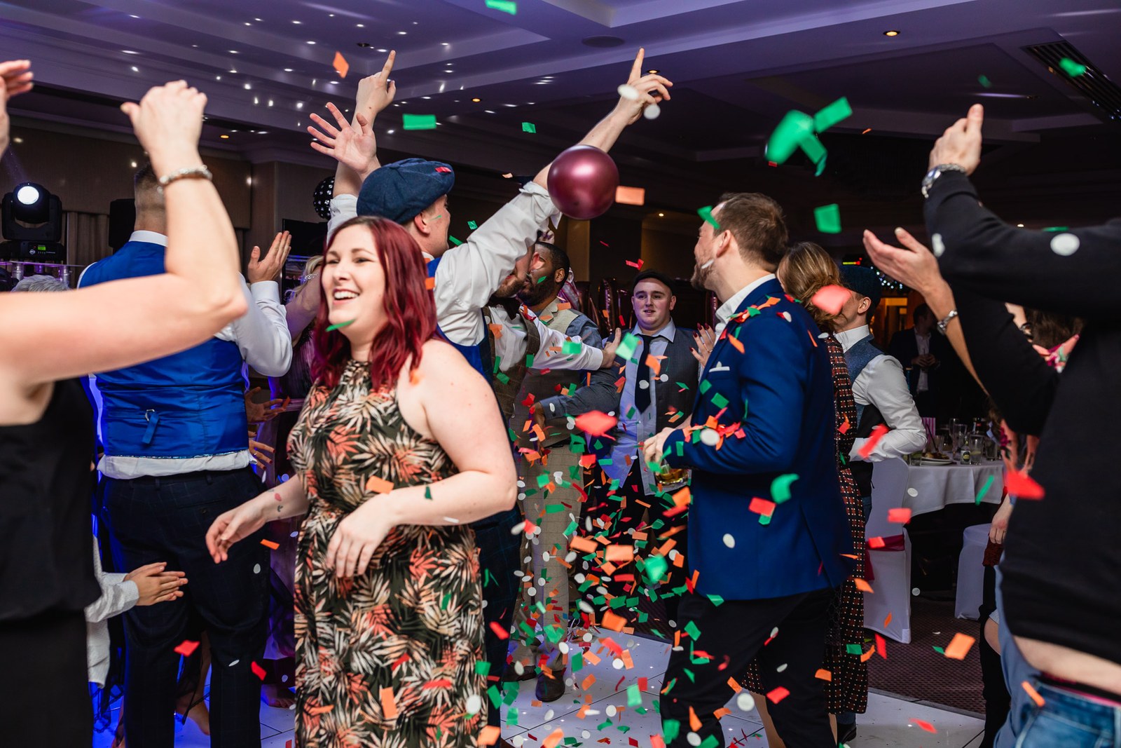 Guests celebrating under a shower of confetti and balloons