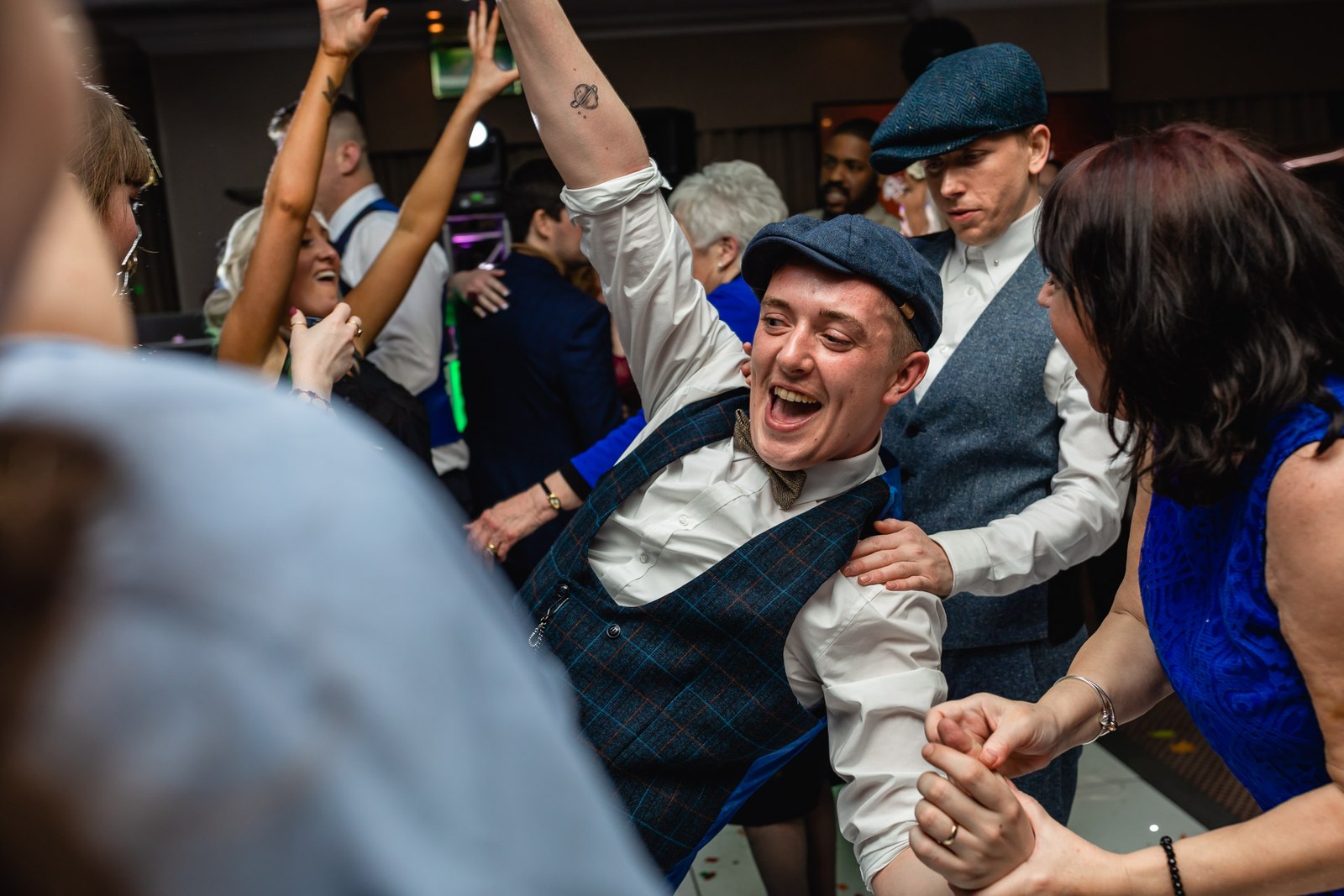 A groom dancing joyfully in the middle of the crowd