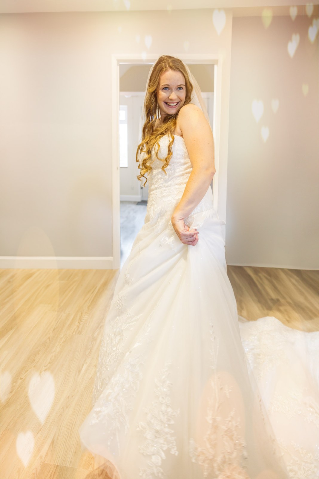 Bride standing in her gown in a sunlit room with heart-shaped bokeh