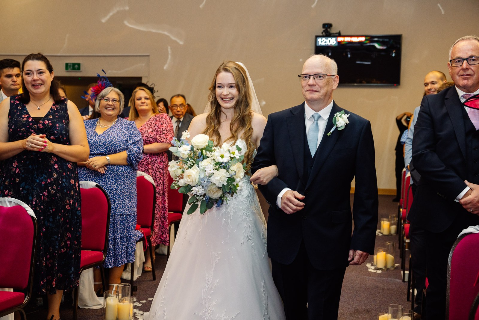 Bride walking down the aisle on her father's arm past standing guests