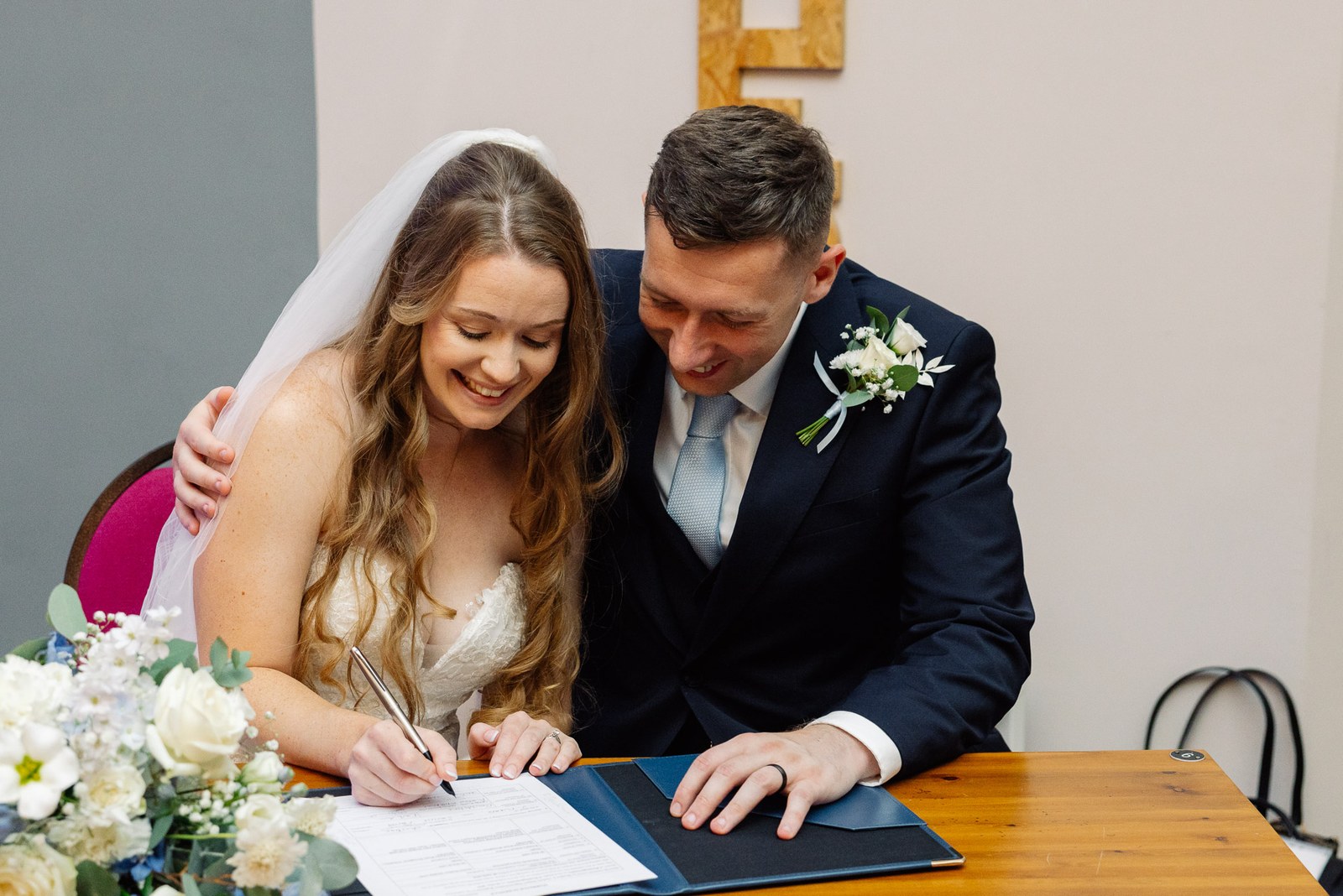 The newlyweds signing the marriage register together