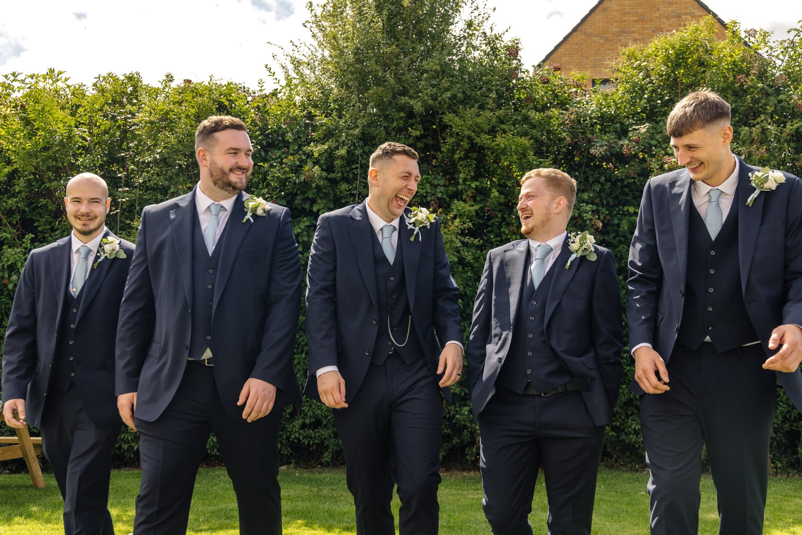 The groom and his groomsmen in navy suits walking the grounds at Winters Tale Country Barn