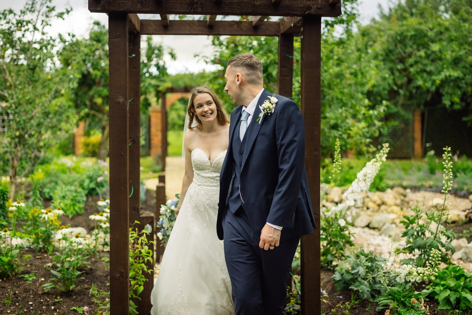 The couple beneath a pergola in the walled garden at Winters Tale Country Barn