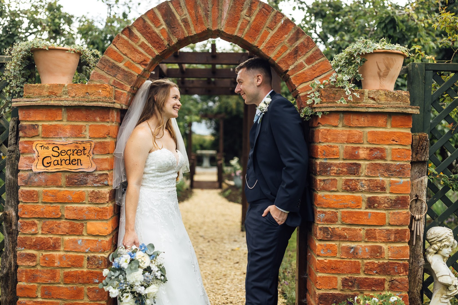 The couple at the secret garden's brick archway at Winters Tale Country Barn