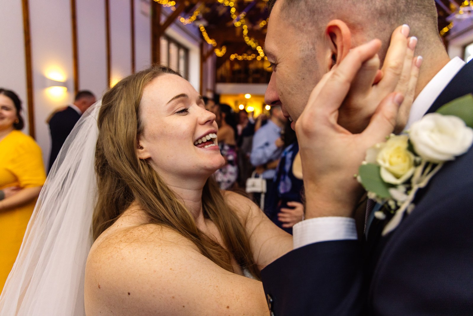 Bride laughing during the first dance as guests look on