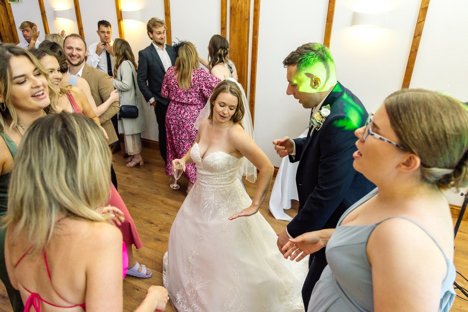 The newlyweds dancing among their guests on the barn floor