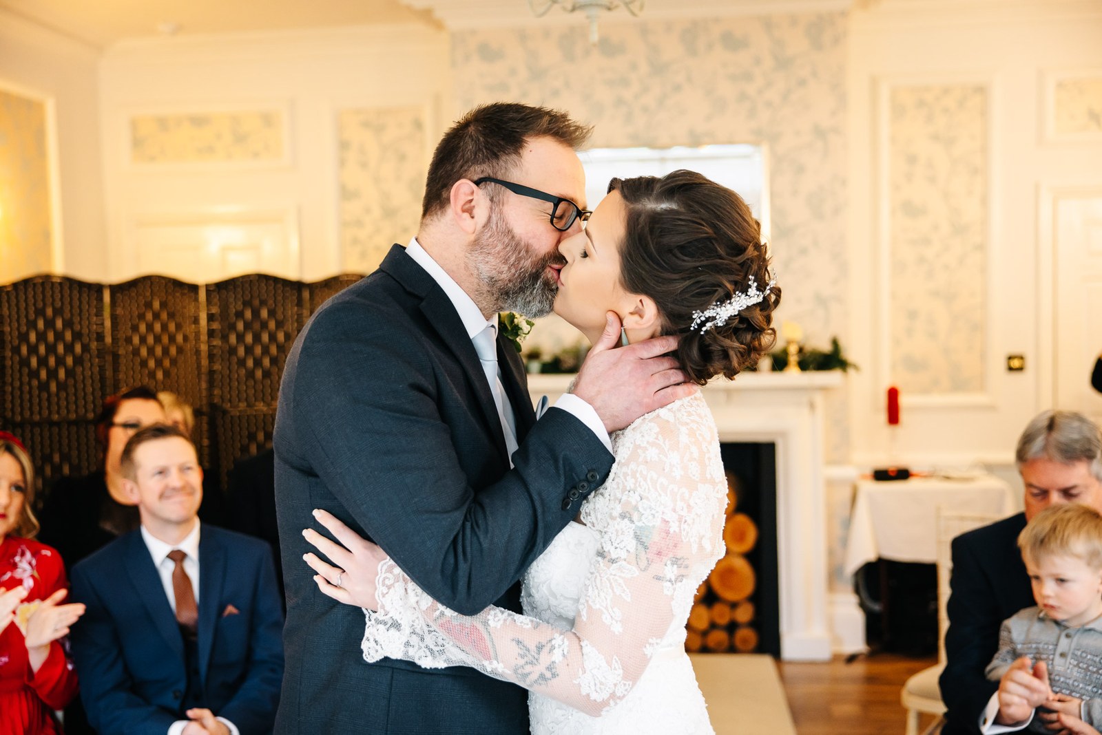 The couple sharing their first kiss as guests applaud