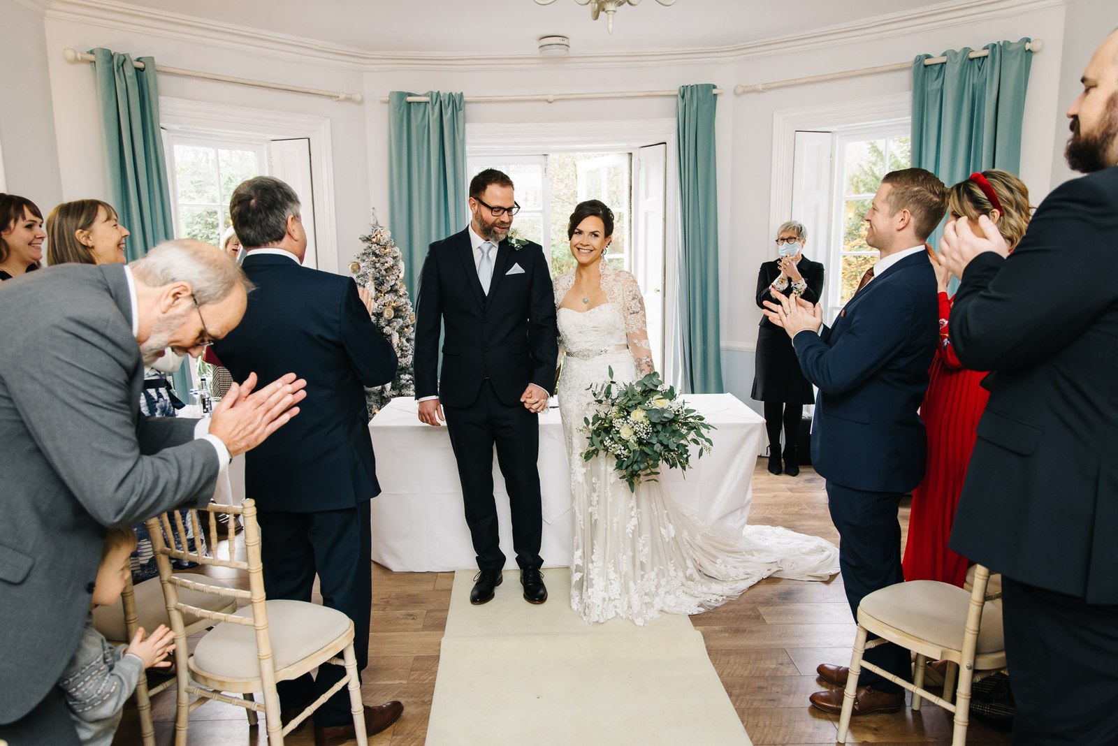 The newlyweds walking back up the aisle to warm applause