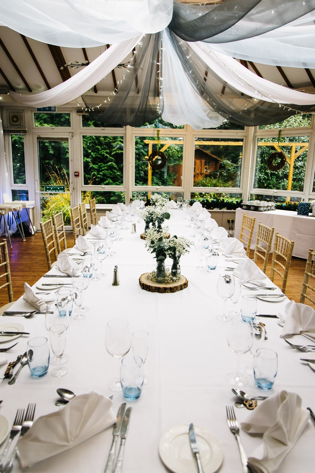 The conservatory at Woodlands Lodge Hotel with the long table beneath draped swags