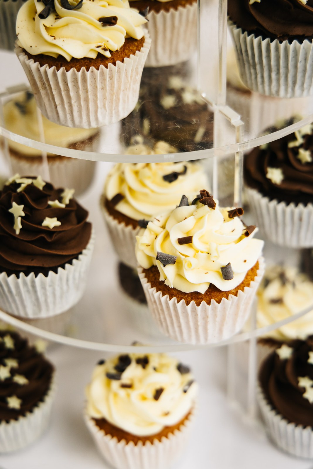 A tiered stand of chocolate and vanilla star-topped cupcakes