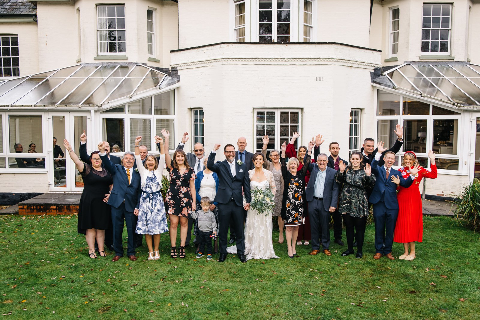 Guests cheering on the lawn before the white facade of Woodlands Lodge Hotel