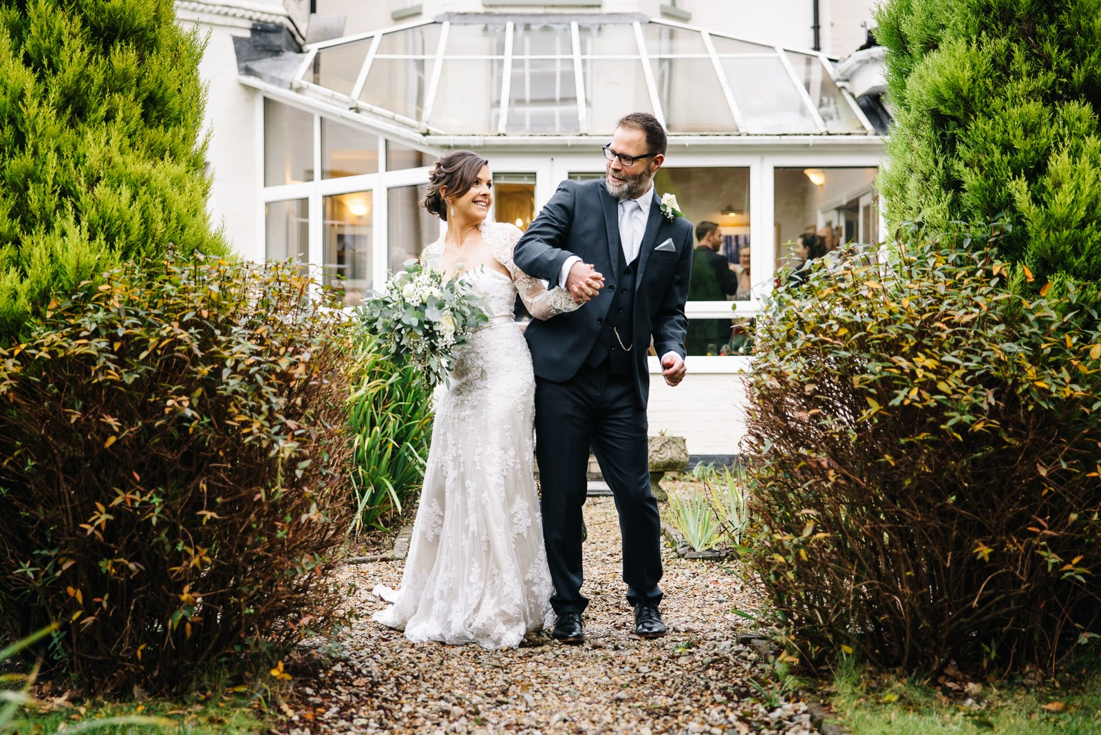 The couple on a garden path before the Woodlands Lodge Hotel conservatory