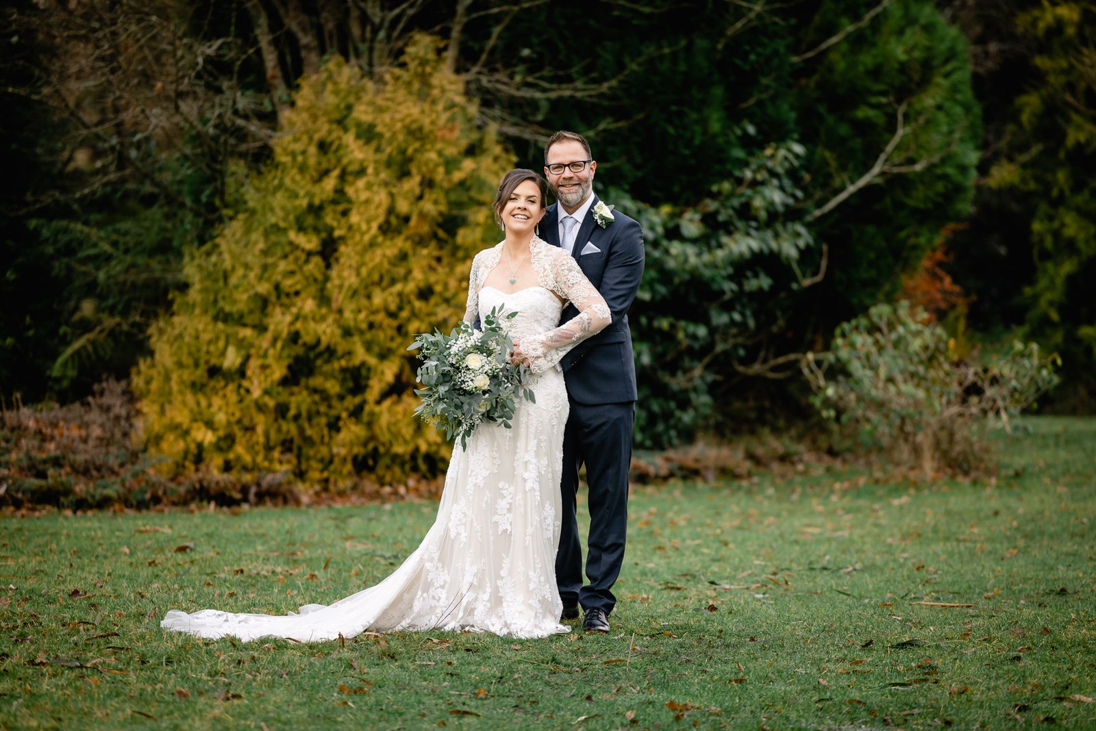 The couple embracing on the Woodlands Lodge Hotel lawn amid autumn foliage