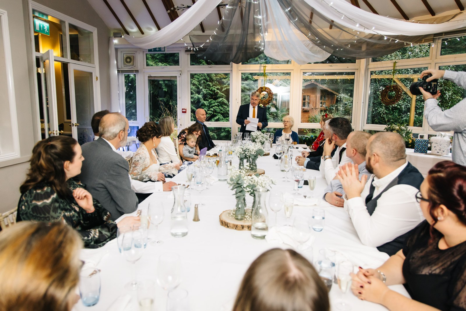 Guests seated along the long conservatory table at Woodlands Lodge Hotel