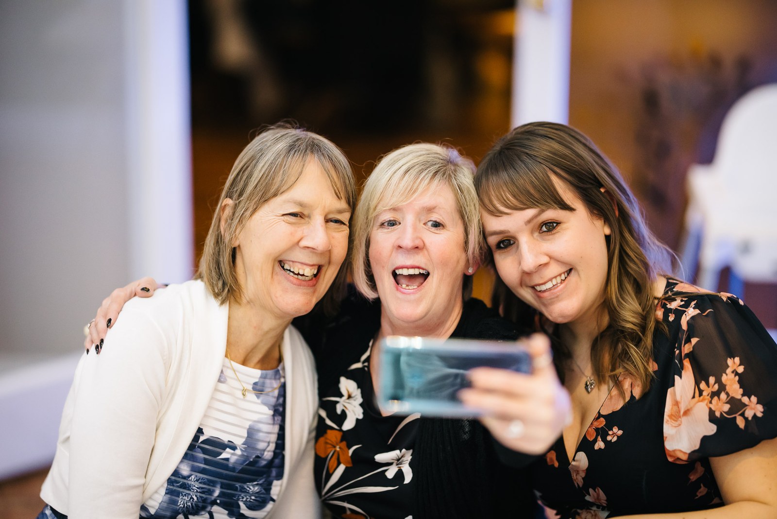Three guests posing for a selfie together at the reception