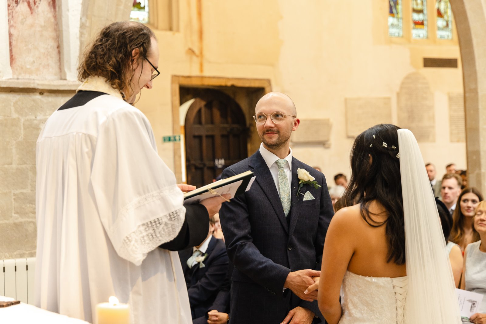 Vicar reading to the bride and groom during the church ceremony.