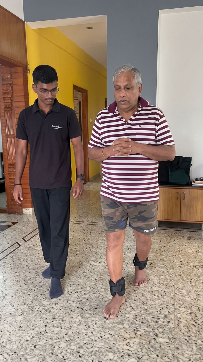 Physiotherapist walking alongside a senior wearing ankle weights during gait training at home