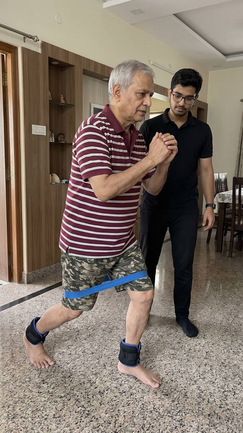 Senior doing a resistance-band step exercise with a physiotherapist guiding him