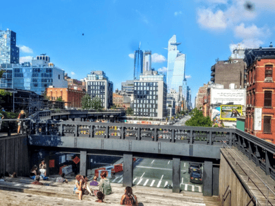 Panoramic view of Chelsea, with modern buildings and residents enjoying the public space in the sun.
