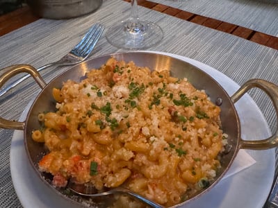Creamy cheese pasta with vegetables, served in an elegant dish at Catch restaurant, creating a gourmet atmosphere.