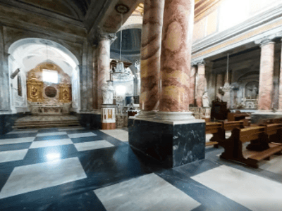 Interior of the Cathedral of Castellaneta, featuring elegant columns and a contrasting marble floor.