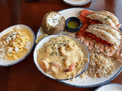 Délicieux repas de fruits de mer au Red Lobster, avec des crevettes, des pâtes et une pomme de terre au four.