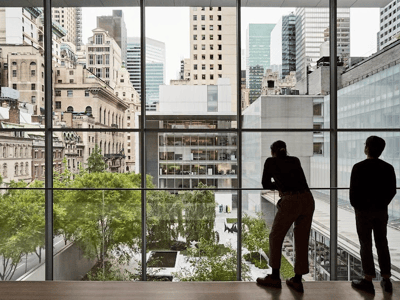 View from the garden of the MOMA in New York, with a visitor contemplating urban modern architecture.