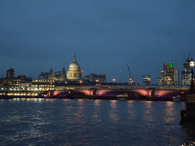 Night view of Westminster Pier with St. Paul's Cathedral illuminated and the lit bridge over the Thames.