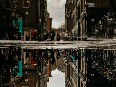 Les rues de Covent Garden reflétées dans une flaque, capturant l'ambiance vivante de ce quartier animé de Londres.