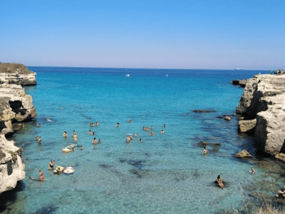 Swimming in the turquoise waters of Melendugno, between cliffs, attracting visitors with its natural landscapes.