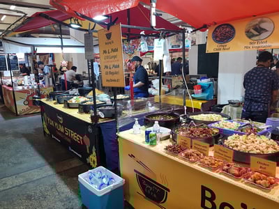 Stands alimentaires colorés au marché de la brasserie Truman, proposant une variété de plats savoureux et de boissons.