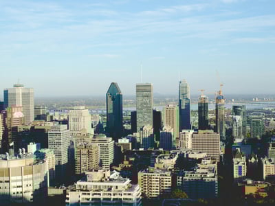 Panoramic view of downtown Montreal, highlighting modern urban architecture and the St. Lawrence River.