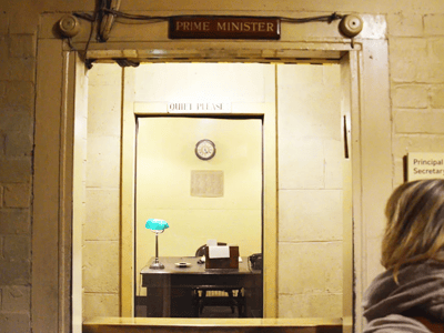 Bureau du Premier ministre aux Churchill War Rooms, avec un lampadaire vert et une horloge, évoquant la stratégie de guerre.