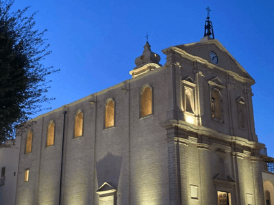 Historic Church of Castellaneta illuminated, showcasing its characteristic architecture under a twilight sky.
