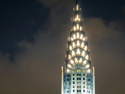 The Art Deco pinnacle of the Chrysler Building illuminated at night, an iconic symbol of New York.