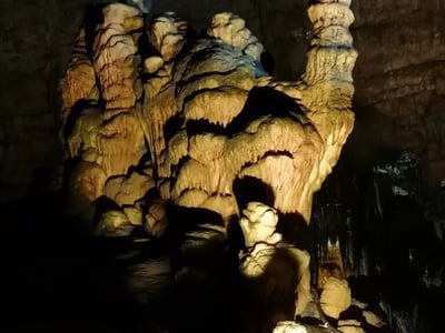 Stalagmites et formations rocheuses illuminées dans les grottes de Castellana, un site naturel impressionnant en Italie.