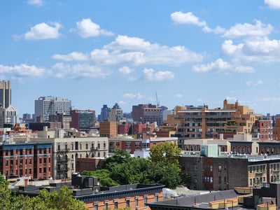Panoramic view of Morningside Park, showcasing the city buildings and the blue sky dotted with clouds.
