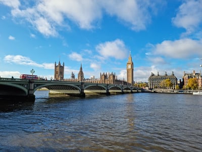 View of Westminster Bridge with Big Ben and the Houses of Parliament in the background, under a clear blue sky.