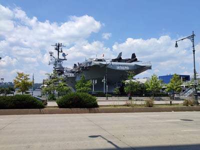Intrepid aircraft carrier, maritime museum in New York, surrounded by greenery and under a blue sky. Enriching historical visit.