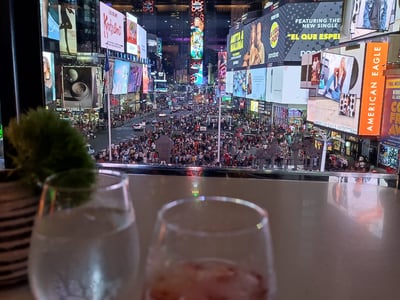Vue animée de Times Square la nuit, avec des lumières vives et des personnes profitant de l'atmosphère citadine.