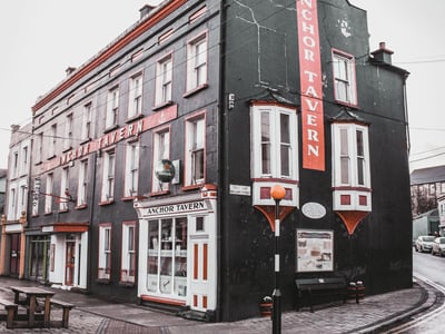 Historic tavern in Beara Peninsula, with a black and red facade, offering a friendly and welcoming atmosphere.