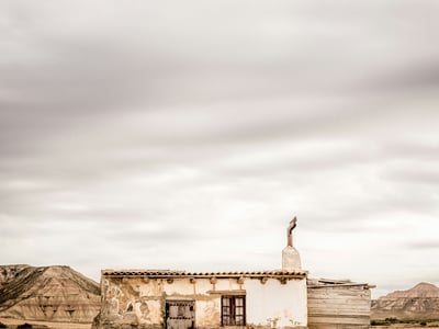 Une ancienne bâtisse en ruine à Arguedas, entourée de paysages désertiques et de collines, évoquant l'histoire locale.