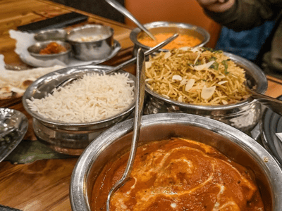 Delicious Indian meal in Delhi 6, with curry chicken, biryani, basmati rice, and various side dishes.