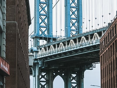 Detailed view of the Manhattan Bridge, with historic buildings framing the iconic architecture of the bridge.