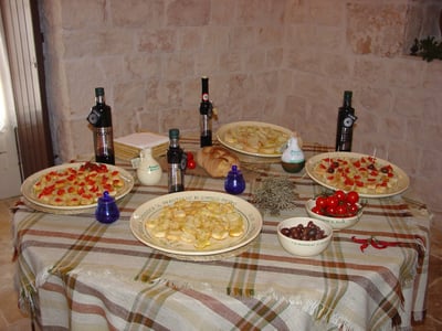 Assiette de spécialités italiennes à Frantolio D'Amico Pietro, avec des olives, des tomates cerises et de l'huile d'olive.