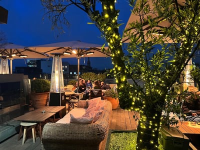 Bright terrace at Boundary Shoreditch, with customers enjoying a relaxing atmosphere under a night sky.