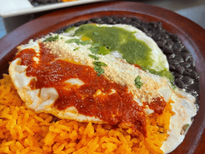 Vibrant Mexican flavors with an egg on a bed of rice, accompanied by red and green sauces, at El Mil Sabores.