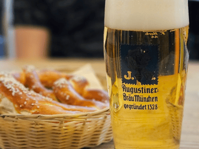 Pinte de bière blonde servie à Augustiner am Gendarmenmarkt, accompagnée de bretzels croustillants.