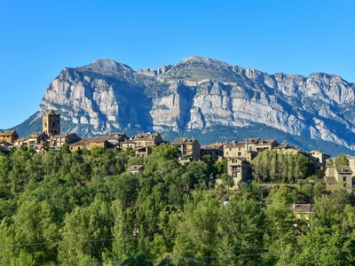 Picturesque village of Aínsa-Sobrarbe, overlooked by majestic mountains, offering an enchanting natural setting.
