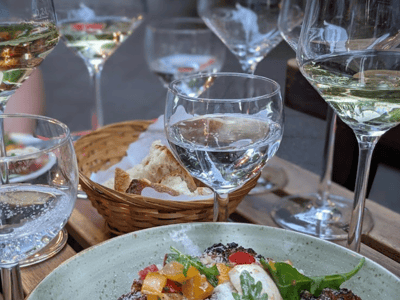 Délicieux plat garni de légumes frais, entouré de verres de vin, à déguster à Facciola, une expérience gastronomique mémorable.